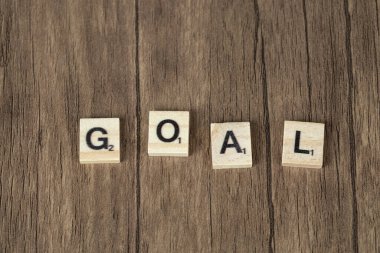 Ahşap zemin üzerindeki tahtadan zarlarda siyah harflerle amaç yazımı