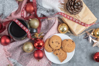 Beyaz bir fincan içinde çıtır çıtır zencefilli kurabiyeler ve bir bardak içki ve noel