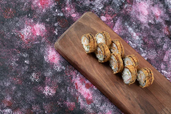 Hot sushi rolls on a wooden board — Stock Photo, Image