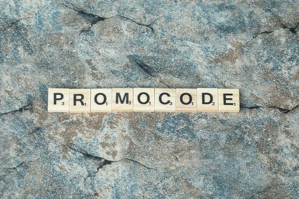 Promocode escritura con letras negras en dados de madera en el hormigón —  Fotos de Stock