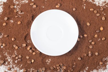 Karışık kahve tozunun üzerinde boş beyaz bir tabak.