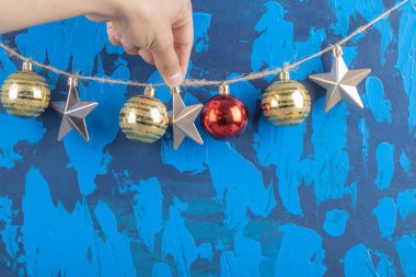 Mavi desenli arka plandaki kırsal iplikten sarkıtılmış renkli süsler