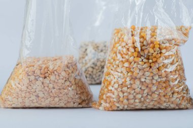 Gri arka planda farklı türde çiğ fasulye.