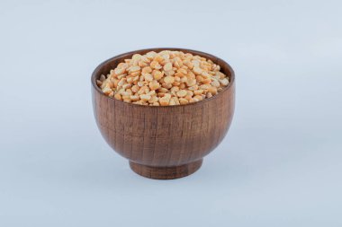 Çiğ mısır taneleriyle dolu küçük bir tahta kase.