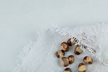 Beyaz kumaş üzerinde kavrulmuş kestaneler.
