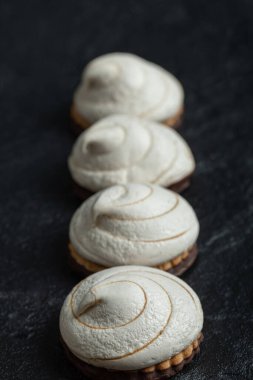 Koyu arkaplanda bir sıra lezzetli kek.