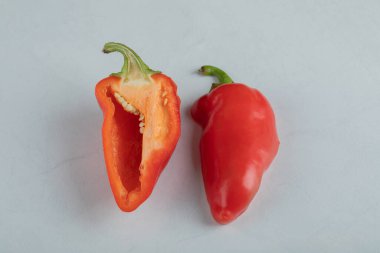 Gri arkaplanda yarısı kesilmiş kırmızı biber