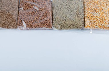 Gri arka planda farklı türde çiğ fasulye.