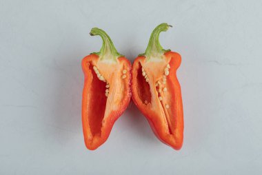 Gri arkaplanda yarısı kesilmiş kırmızı biber