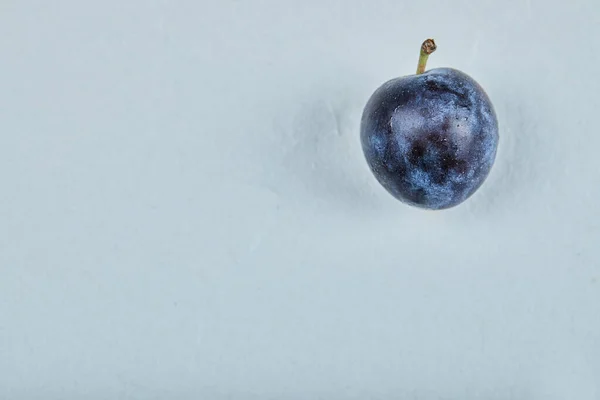 Prune fraîche isolée sur fond bleu — Photo