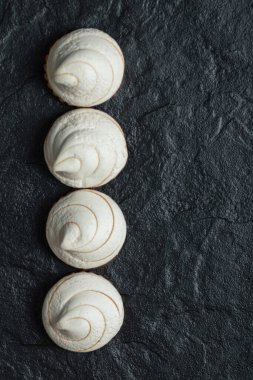 Koyu arkaplanda bir sıra lezzetli kek.