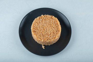 Beyaz zemin üzerinde koyu tabakta Türk yemek bulguru pirinci