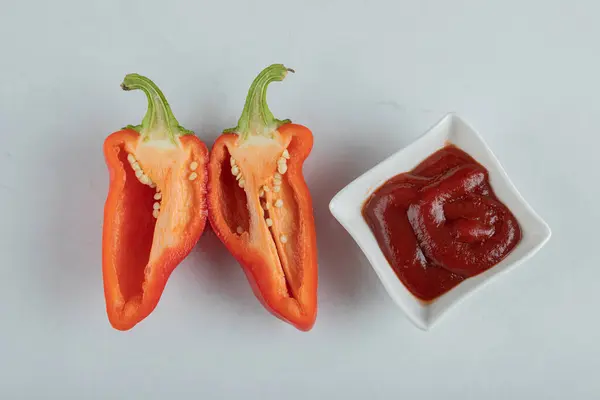 Kusy červeného pepře s kečupem na šedém pozadí — Stock fotografie