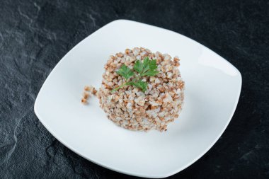 Lezzetli karabuğday, beyaz tabakta yeşillikler.