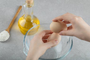 İki taze tavuk yumurtası tutan kadın eller.