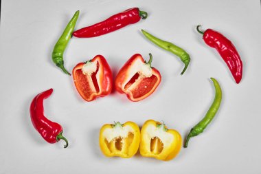 Beyaz arka planda dolmalık biber ve kırmızı biber dilimleri