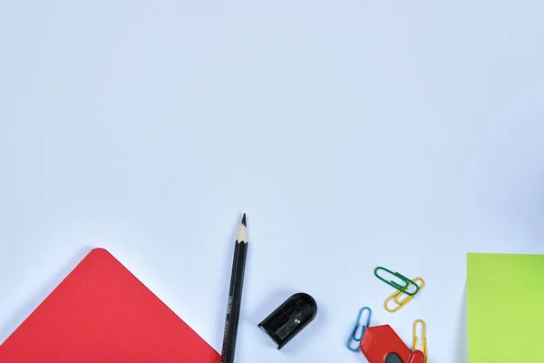 Material de escritório, caderno, lápis e clipes sobre fundo azul — Fotografia de Stock