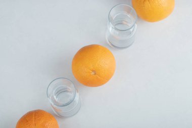 Boş cam sürahilerle taze portakal meyveleri.