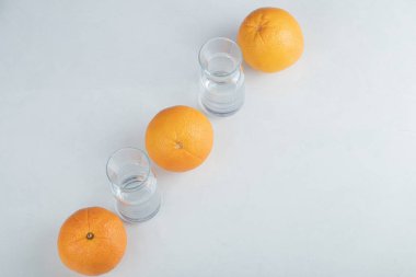 Boş cam sürahilerle taze portakal meyveleri.