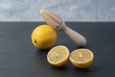 Taze sarı dilimlenmiş ve ahşap bir limonla dolu.