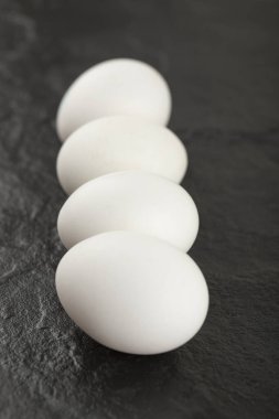 Siyah arka planda beyaz tavuk yumurtası.
