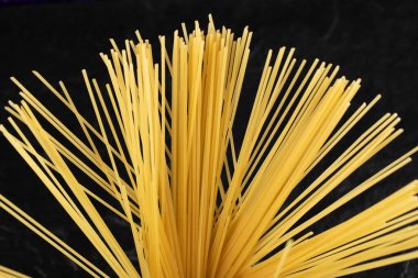 Siyah arka planda çiğ spagetti.