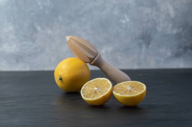 Taze sarı dilimlenmiş ve ahşap bir limonla dolu.