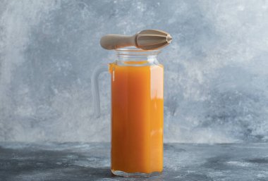 Cam sürahide portakal suyu ve ahşap bir kağıt.