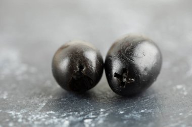 Mermer zemin üzerinde iki siyah zeytin meyvesi