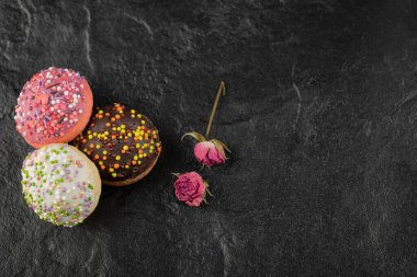 Siyah arka planda serpiştirilmiş tatlı küçük çörekler