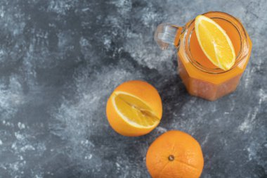 Portakal suyu ve dilimlenmiş meyveli cam sürahi.