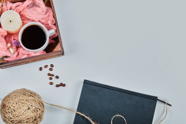 Mavi mumlu kitap ve beyaz arka planda bir sepet kahve.