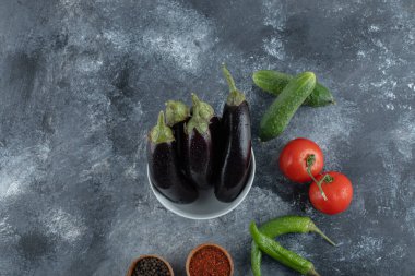 Gri arka planda baharatlı taze sebzeler.