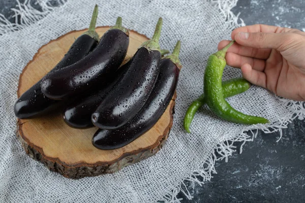 Verdure fresche crude. Mucchio di melanzane e pepe verde che tiene con mano — Foto Stock