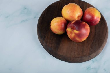 Tahta bir tabakta sarı kırmızı şeftali