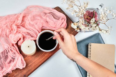 Tahtada bir bardak kahveyi mumla tutarken.