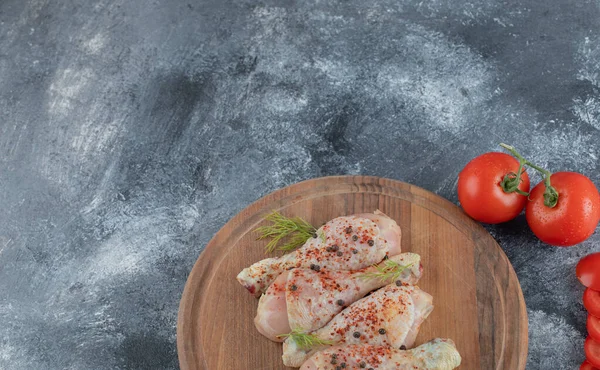 Rauwe kippenpoten met specerijen op een houten plank — Stockfoto