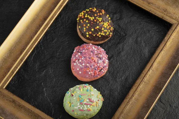 Zoete kleine donuts met hagelslag op een zwarte achtergrond — Stockfoto