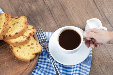 Tahtada bir bardak içkiyle servis edilen tatlı turta.