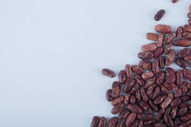 Beyaz yüzeyde pişmemiş kırmızı fasulye yığını.