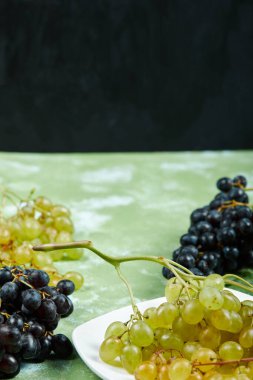 Yeşil ve siyah arka planda bir demet üzüm.