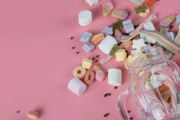 Kleurrijke marshmallows en jellybeans op een roze achtergrond — Stockfoto