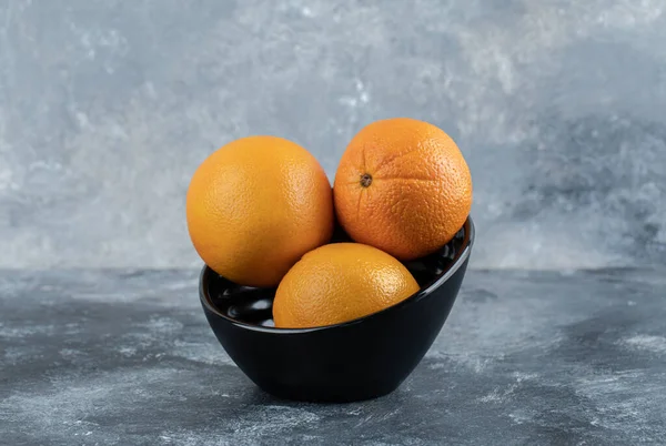 黒のボウルに3つの新鮮なオレンジ 高品質の写真 — ストック写真