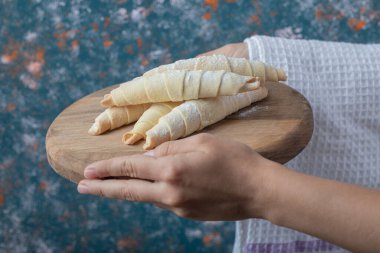 Elinde ahşap bir tahtanın üzerinde mutaki kurabiyeleri tutuyor. Yüksek kalite fotoğraf