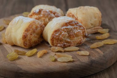 Kuru üzümlü ve ahşap tahtada tatlı şeyler bulunan kızarmış rulo kurabiyeler. Yüksek kalite fotoğraf