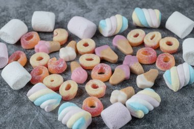 Mermer zemin üzerinde karışık şekilli şekerlemeler ve jelibonlar. Yüksek kalite fotoğraf
