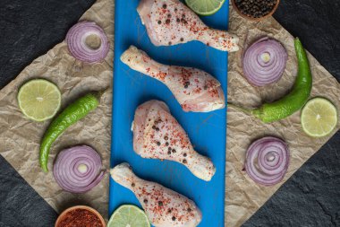 Ahşap tahtada salamura edilmiş tavuk budu ve siyah arka planda sebzeler. Yüksek kalite fotoğraf