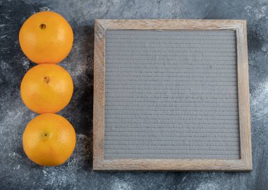 Üç lezzetli portakal ve mermer kaplama çerçeve. Yüksek kalite fotoğraf