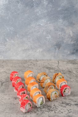 Mermer zemine yerleştirilmiş lezzetli suşi ruloları.