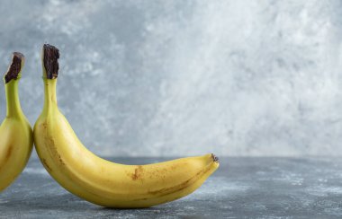 Gri arka planda iki olgun muz